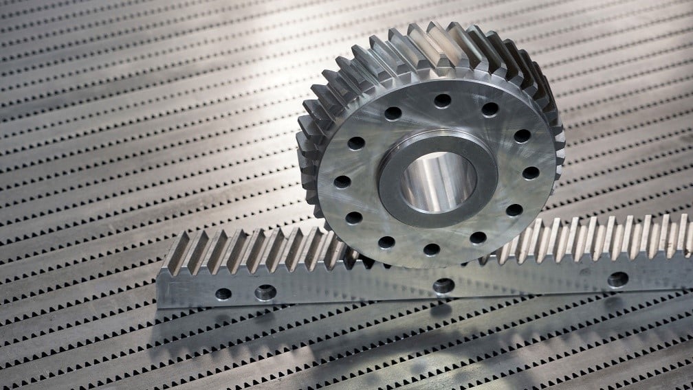 Sistema cremagliera e pignone in acciaio: dettaglio dell'ingranaggio con denti elicoidali per trasmissione del movimento lineare